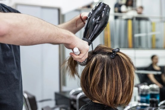 Stylist applying seamless hair extensions during Best Hair Extensions in Richmond service at Salon Victoria Makeup & Hair Lounge